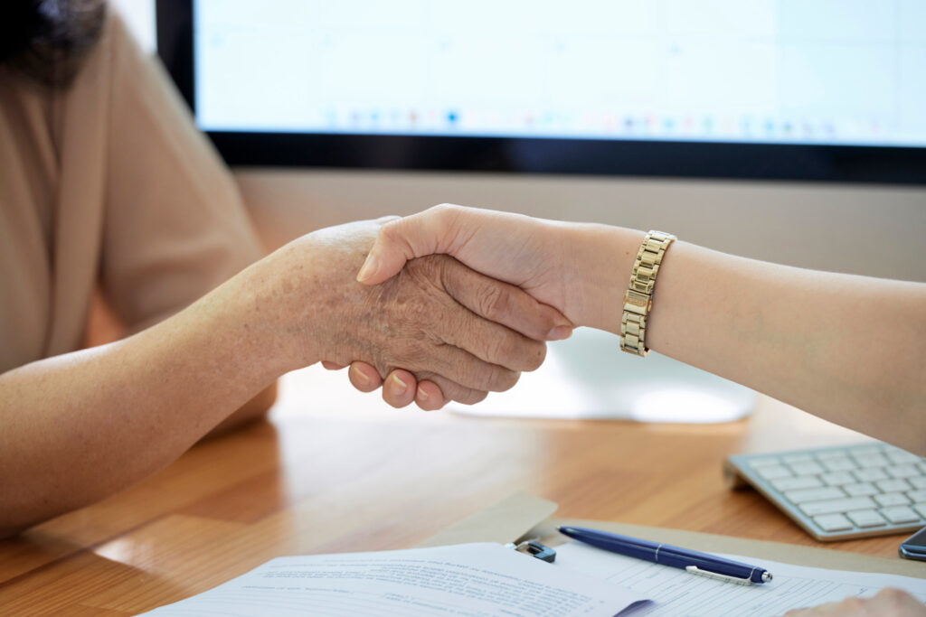 Dos personas dándose las manos tras llegar a un pacto sucesorio